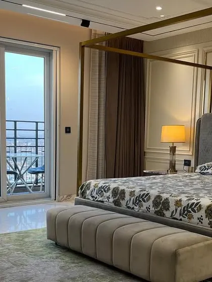A beautifully appointed master bedroom with a four-poster bed and a balcony view. Our technology is designed to complement such grandeur, with discreet controls for lighting and automated curtains.