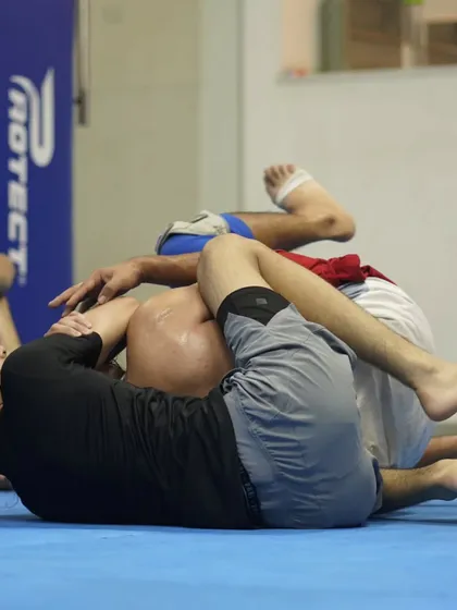 A close-up of a grappling exchange. Students work on maintaining dominant positions and looking for submissions in a live roll.