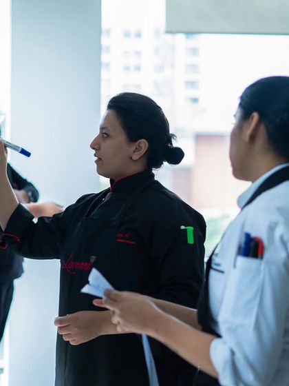 A mentor guiding her students. We believe in the power of mentorship to help our students find their best selves in the kitchen.