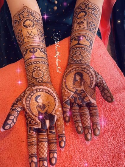 A full view of a beautiful engagement mehendi, showcasing portraits of the couple within circular frames on the palms. The arms are decorated with traditional architectural and swan motifs.
