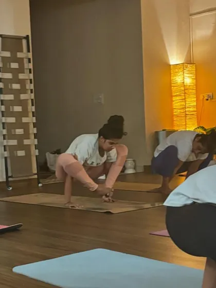 Students working on arm balances like Bakasana (crow pose). This builds upper body strength, core stability, and focus.