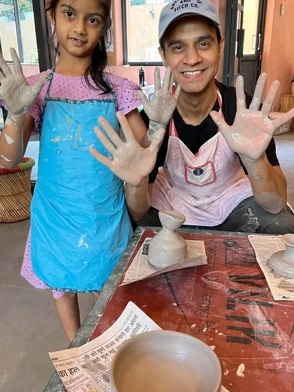 Messy hands, happy hearts. A father and daughter proudly show off their clay-covered hands after a fun-filled Father's Day pottery session.