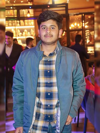 A portrait of a young man at an indoor party. My photos are sharp and well-composed, even in low-light settings.
