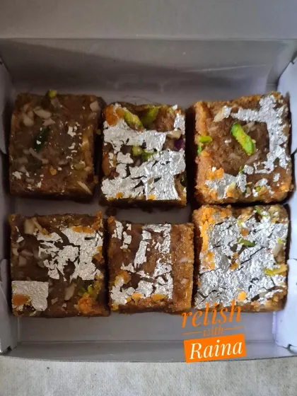 A small box of Moong Daal Barfi with silver vark. The secret is roasting the lentils in pure ghee for hours on a slow flame.