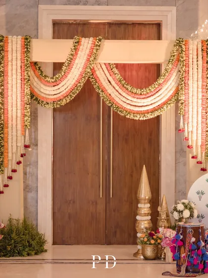 A beautiful floral 'toran' made of tuberose and marigold garlands, a traditional and auspicious way to welcome guests to a wedding ceremony.
