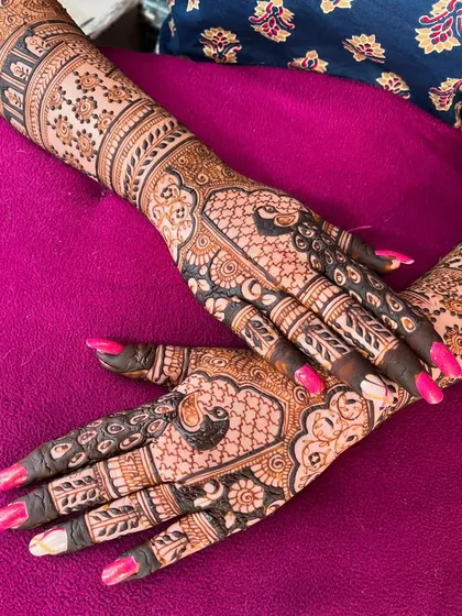 A gorgeous bridal mehendi with a focus on peacock motifs. The design is a beautiful example of traditional Indian henna art, perfect for a destination wedding.