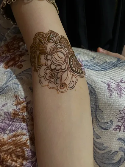 A delicate floral band on the elbow, part of a larger bridal piece. Every detail matters when it comes to bridal henna.