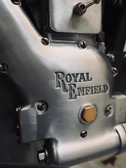 The beautifully restored Royal Enfield engine casing, showing the original cast texture and branding from 1955.