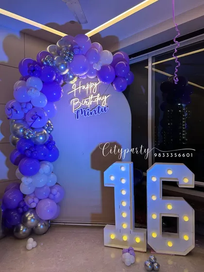 A still shot of the 16th birthday decoration, showing the purple and silver balloon arch.