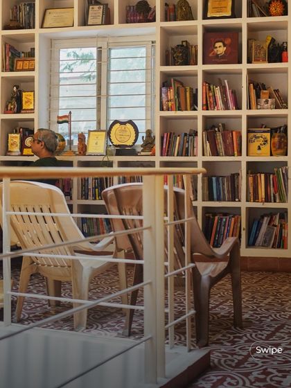 A view from the upper level looking down onto the library. The open design creates a visual connection between floors, making the home feel larger and more integrated.