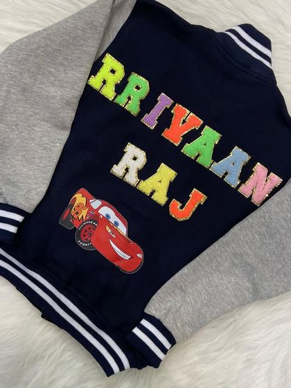 A 'Cars' themed varsity jacket for a little racing enthusiast. The navy and grey combination is classic, while the patches add a touch of fun.