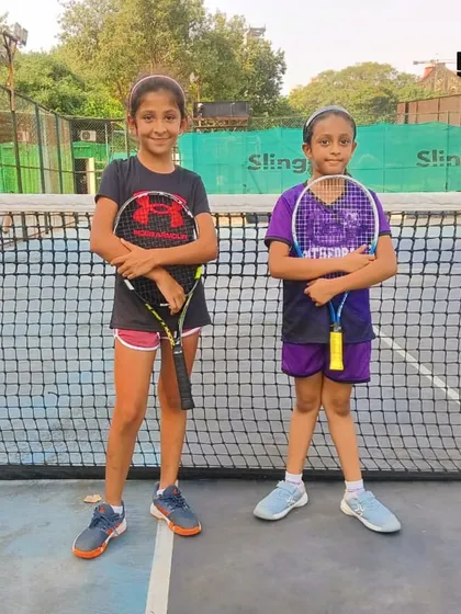 Future tennis stars in the making! Two young girls pose by the net at the inter-school MSSA tournament.