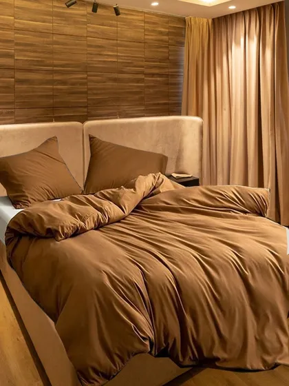 In this bedroom, we used the bed's headboard as a clever partition to create a hidden walk-in wardrobe space behind it. This innovative layout maximizes functionality while maintaining a clean, uncluttered look in the main sleeping area.