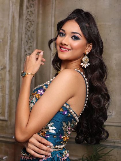 A beautiful shot of the half-up hairstyle, which keeps the hair off the face while still showing off its length and volume. The blue eyeshadow adds a touch of modern glam.