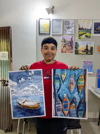 This talented student is showing two of his recent watercolor paintings. One is a serene seascape with a lone boat, and the other is a vibrant composition of colorful boats.