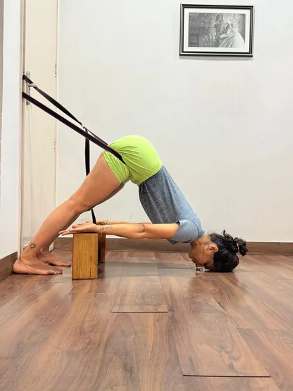 This is a supported Adho Mukha Svanasana with a rope and blocks. Women, whose intelligence is ruled by the heart, are often more enlightened to take to yoga to gain emotional peace and poise. However, men are now realizing its importance as a remedy for stress and strain.