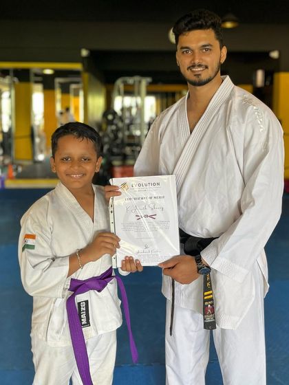 This young student proudly accepts his certificate, marking his promotion to the next belt level.