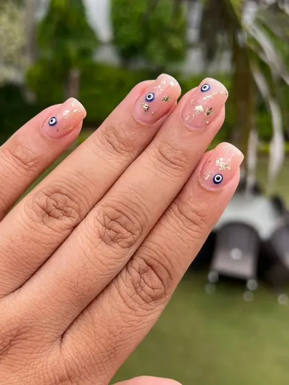 A popular and stylish choice, these natural-looking gel extensions feature delicate, hand-painted evil eye designs and small gold foil flakes for a touch of protection and sparkle.