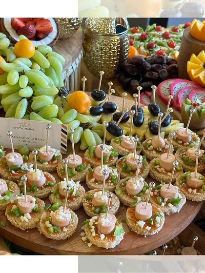 A platter of savory canapés featuring sausage and cheese on a textured cracker. The jewel-like skewers add a touch of glamour to these delicious bites.