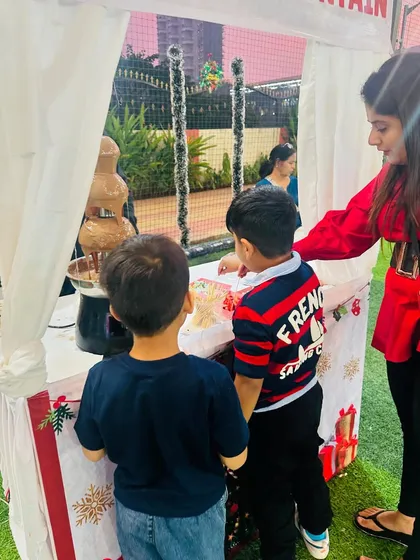 Two young boys getting ready to enjoy the chocolate fountain at a Christmas-themed party. It's the perfect warm treat for a festive event.