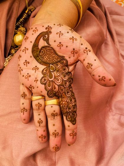 A simple and elegant peacock motif on the back of the hand. This is a perfect choice for someone who wants a touch of traditional art in a minimalist style.