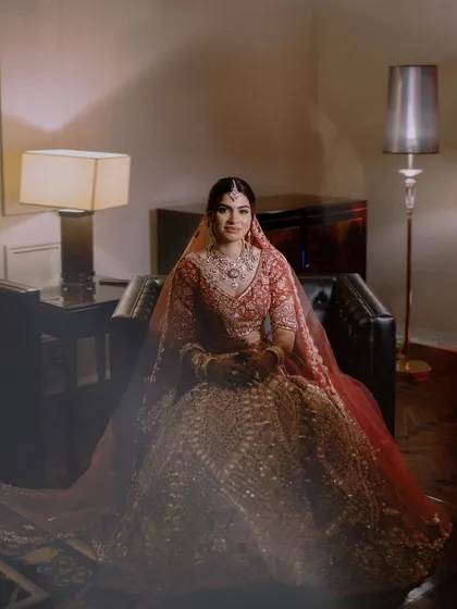 A classic bridal portrait, seated in a leather chair. The soft lighting and elegant pose create a timeless and sophisticated image.