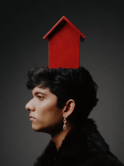 A surreal and conceptual portrait from the same series, featuring a small red house placed on the model's head. This demonstrates my strength in concept development and creating thought-provoking visuals.