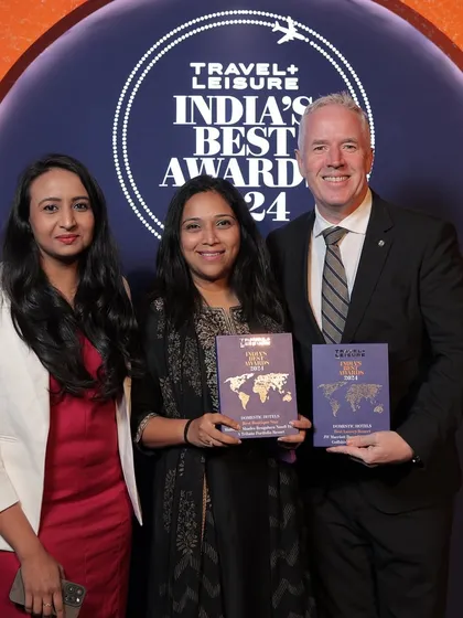 Our team proudly poses with the Travel + Leisure India's Best Award for 2024, a testament to our dedication to exceptional experiences.
