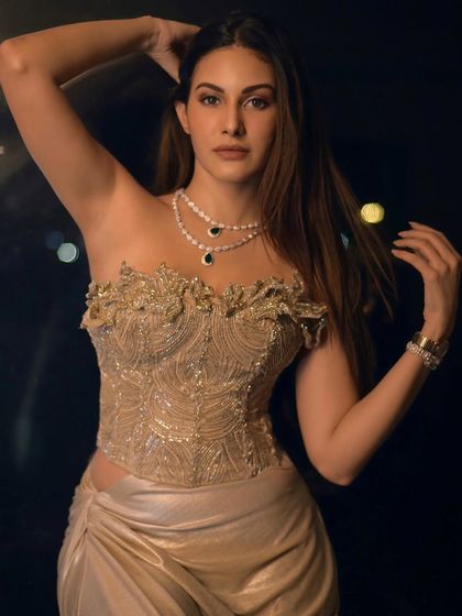 A powerful and confident pose from Amyra Dastur. The lighting highlights her expression and the intricate details of her outfit.
