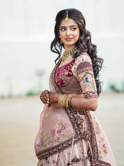 A solo portrait of Charitha, showcasing her reception hairstyle with soft waves and a beautiful, glowing makeup look that enhances her features.