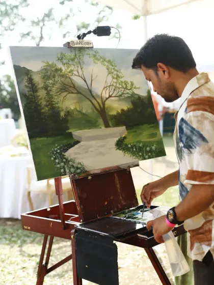 Vivek working on the lush green background for the wedding painting. The first step is always to create the perfect setting for the couple's portrait.