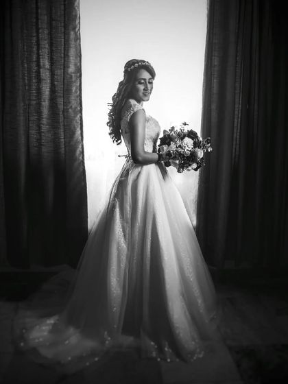 A classic black and white bridal portrait by a window. The soft, directional light creates a timeless and elegant look.