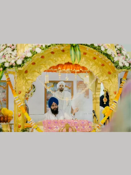 A view of the groom during the Anand Karaj ceremony, framed by the ornate golden Palki Sahib.