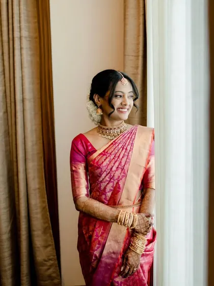 A series of photos capturing the grace of this South Indian bride. Her look features traditional temple jewelry, a silk saree, and a fresh, dewy makeup finish with a classic floral hair bun, embodying timeless elegance.