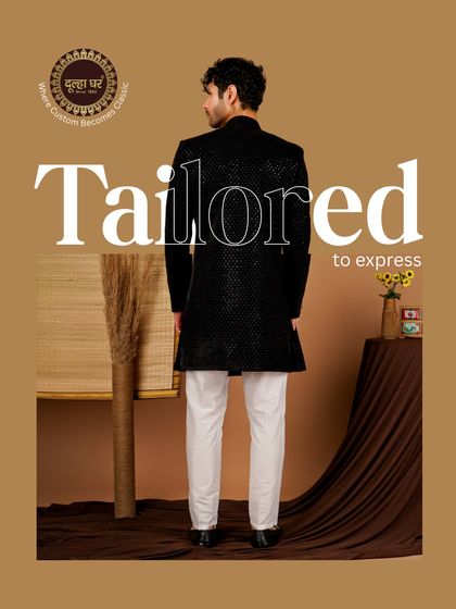 Tailored to express, crafted to impress. A back view of a black textured sherwani paired with white trousers, showcasing a sharp and modern contrast.