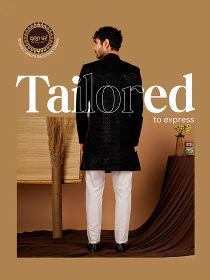 Tailored to express, crafted to impress. A back view of a black textured sherwani paired with white trousers, showcasing a sharp and modern contrast.