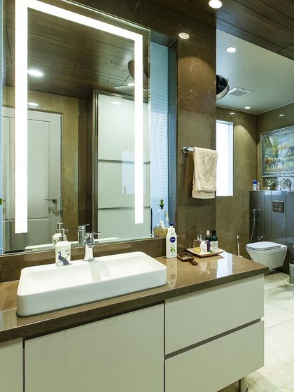Designing a washroom requires a careful balance of style and function. Here, we ensured the aesthetic flows seamlessly from the main interiors, using warm wood tones and a modern floating vanity.