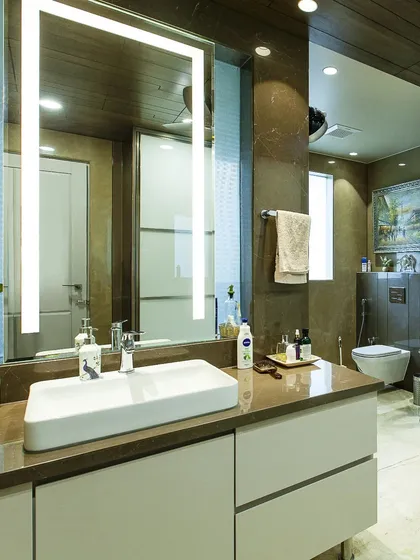 Designing a washroom requires a careful balance of style and function. Here, we ensured the aesthetic flows seamlessly from the main interiors, using warm wood tones and a modern floating vanity.