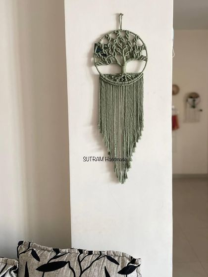 A full view of the sage green Tree of Life hanging in a home setting. It adds such a lovely, natural element to the room.