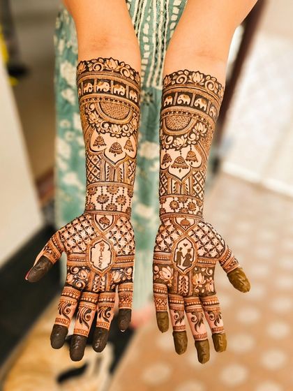 A full view of a narrative bridal henna, featuring portraits and elephant motifs.