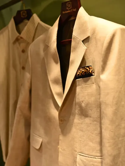 A classic beige blazer paired with a striped shirt, a timeless combination. The pocket square adds a touch of personality, completing the look.