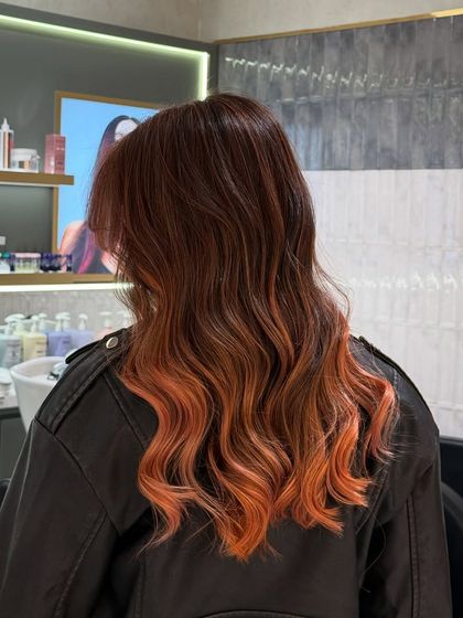 A back view of the ginger glow balayage, showing how the lighter, peachy-orange ends pop against the darker roots.
