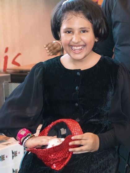 A candid shot of a young girl with a big smile, enjoying the festivities at her birthday party.