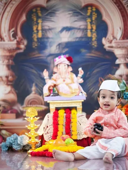 Adding a Gandhi topi to the traditional attire, this little one looks absolutely adorable while celebrating in our Ganpati-themed studio.