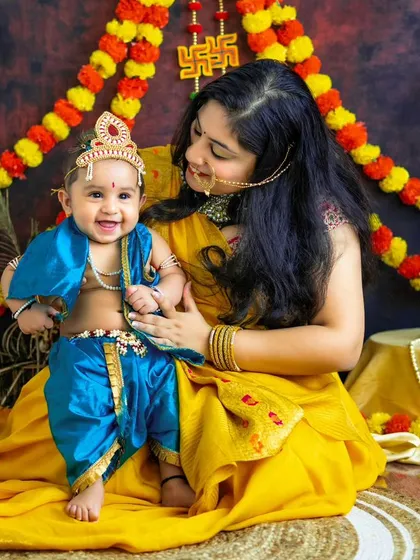 The timeless love of Yashoda and her little Krishna. This beautiful portrait of a mother and son captures the divine bond in a festive setting.
