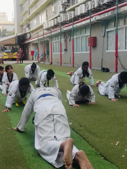 Students perform push-ups in a line. We train as a team, pushing ourselves and motivating the person next to us.