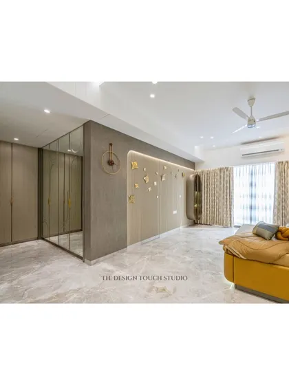 This shot showcases a full wall of mirrored wardrobes, which create a seamless and modern look while providing ample storage. The reflection adds depth and a touch of glamour.