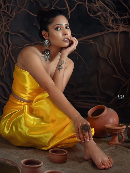 A direct and engaging portrait from the yellow satin series. The model's pose and eye contact draw the viewer in, while the earthy set provides a rich, textural context.