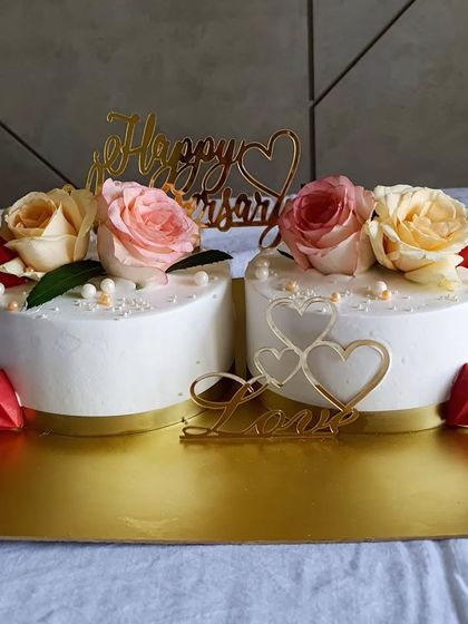 Florals are my favourite. These matching semi-circle cakes come together to form a heart shape, decorated with fresh roses and gold toppers for a beautiful anniversary celebration.