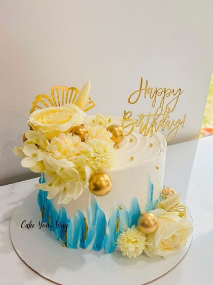 A slice of elegance, crafted to perfection. A blue and white cake with yellow flowers.